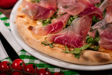White pizza with prosciutto crudo, arugula and parmesan