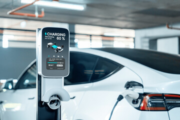 EV electric car recharge at shopping center parking lot charging in downtown city showing urban...