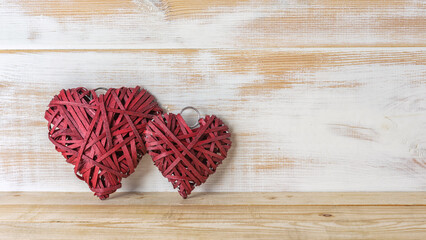 Wicker hearts made of straw on wooden background with copy space. Valentine day or love concept.