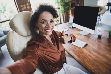 Photo of beautiful successful lady agent sit chair make selfie demonstrate thumb up empty space...