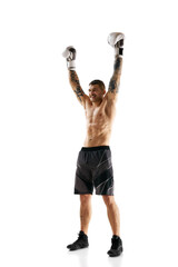 Winner, champion. Young shirtless man with muscular strong body, boxing athlete raising hand isolated over white background. Concept of professional sport, combat sport, martial arts, strength