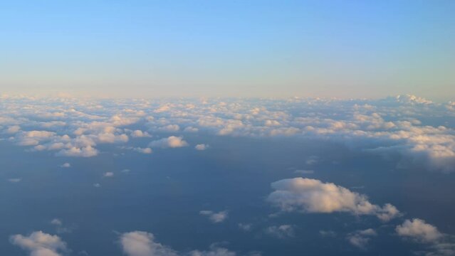 Window view of cloudy sky at sunset. Flying at cloud level