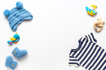Set of baby boy dress - blue bodysuit with knitted hat and boots, top view. Kids clothing flat lay