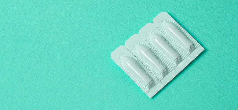 vaginal suppositories on mint background. Top view. Treatment of vaginal infections from sexually transmitted infections. Woman health. Contraception, birth control. Planning pregnancy