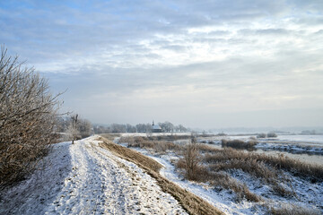 flood embankment wooden church over the Warta River during winter - obrazy, fototapety, plakaty