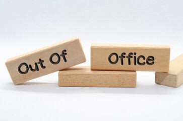 Out of office text on wooden blocks with white background. Out of office concept