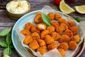 Crispy  deep fried   chicken  nuggets . Breaded  with Cornflakes Breast fillets  with chilly peppers and fresh   basil on wooden rustic background