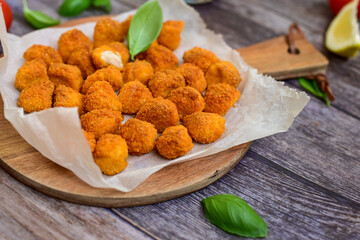 Crispy  deep fried   chicken  nuggets . Breaded  with Cornflakes Breast fillets  with chilly peppers and fresh   basil on wooden rustic background