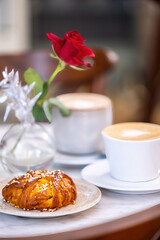 Stockholm, Sweden A cozy cafe table with a Swedish fika or coffee break and sweet cinnamon bun.