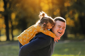 Joyful dad hugs his little smiling daughter. Single daddy and child have fun, laugh and enjoy...