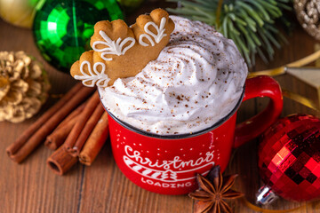 Iced gingerbread latte drink, tasty Christmas New Year beverage hot chocolate or coffee cocktail with whipped cream and gingerbread syrup, with whipped cream, and gingerbread cookie spices 