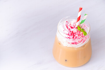 Iced Peppermint Mocha or Latte, Christmas coffee drink with crushed candy canes, whipped cream and mint syrup, festive holiday cold drink 