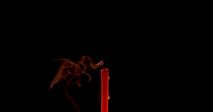 Extinguishing a thin candle on a dark background