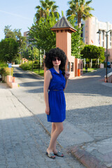 Beautiful woman in a blue dress on a city street.