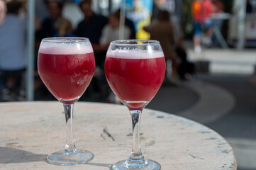 Famous fresh brewed red lambic kriek cherry beer served outside in Belgian beer festival in Durbuy,  special Belgian beer glass in sun lights
