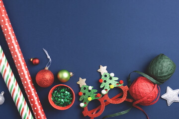 Dark blue New Year background with red and green festive Christmas toys, holiday decorations and...