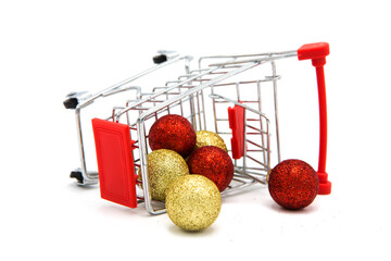 Overturned supermarket grocery shopping cart with scattered Christmas tree toys isolated on white...