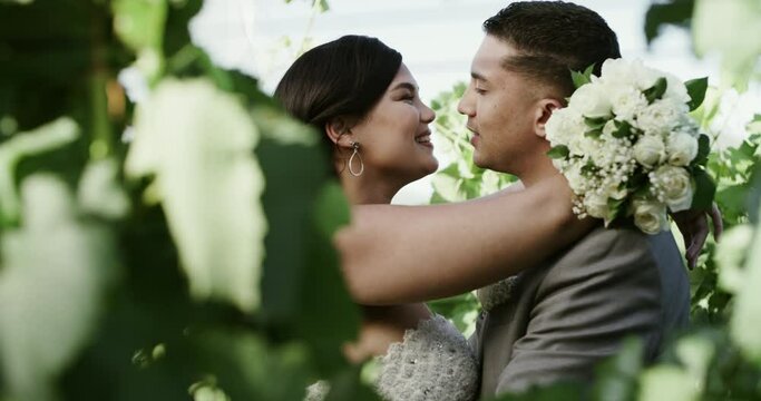Kiss, woman and man in garden at wedding with love, flowers and commitment for couple at reception. Romance, bride and groom embrace in nature for marriage with bouquet, care and future together.