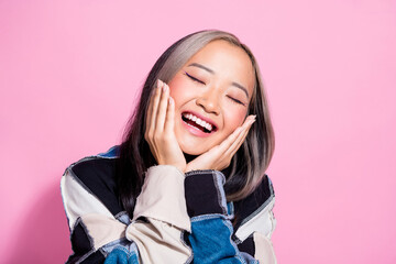 Portrait of good mood woman with dyed hairdo wear oversize sweatshirt palms on perfect skin cheekbones isolated on pink color background