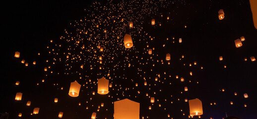 Thai people release sky floating lanterns or lamp to worship Buddha's relics at night. Traditional...