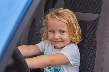 child girl in the car, a little girl is sitting in a car
