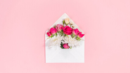 Natural red and white flowers buds in open white envelope. Valentine's, mother's day holiday, wedding and and other occasions.