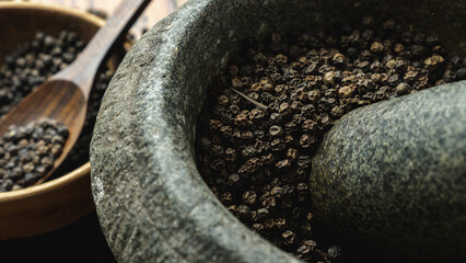grinding and crushing black peppercorn with mortar and pestle