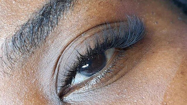 close up of eyelash extensions in beauty salon macro eye ,2d volume 3d volume,russian volume, classical style, remover,patches,lash technician,beautician,lashmaker,cat eye.black skin woman