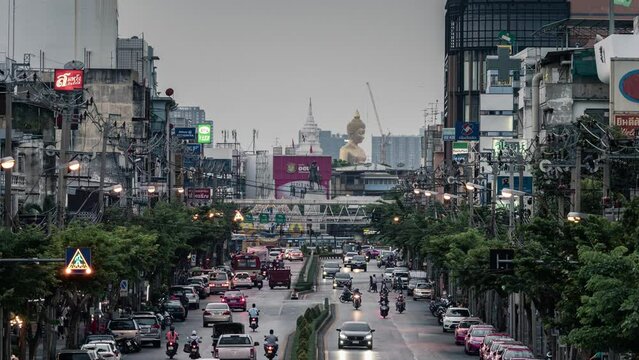 Cityscape of buildings with traffic on the road and golden large buddha in downtown