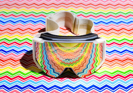 Ski goggles reflecting a colorful zigzag patterned surface
