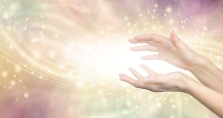 Sending high vibe distant healing - female hands sensing white healing vibes against golden  ethereal energy field background with copy space for message
