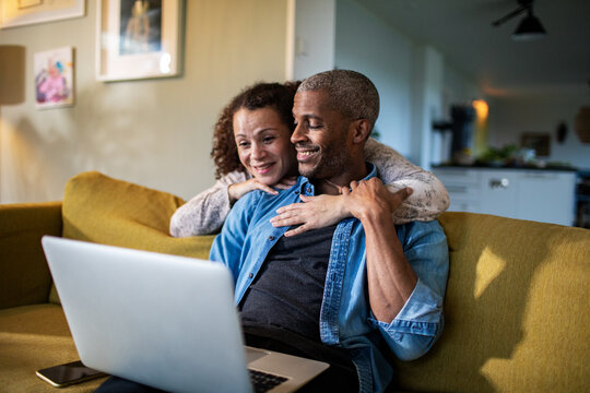 Happy Couple Using Laptop Together At Home