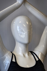 A white faceless mannequin in a store in PA.  Light reflects on this plastic female form.