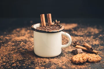 Foto op Plexiglas Homemade spicy hot chocolate drink with cinnamon stick, star anise, grated chocolate in enamel mug on dark background with cookies, cacao powder and chocolate pieces © O.Farion