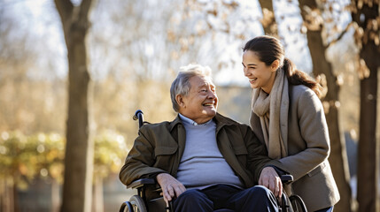 Senior man in wheelchair with his daughter in autumn park