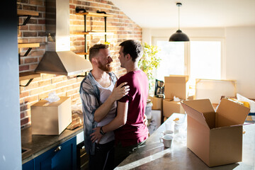 Happy gay couple hugging in new home