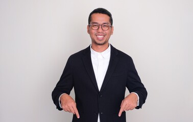 Fototapeta premium Asian businessman smiling confident with both hands pointing below