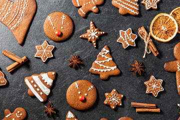 baking, cooking, christmas and food concept - close up of iced gingerbread cookies, cinnamon and...