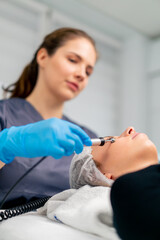 a beautician doctor massaging the skin of a client's face during a beauty and health cosmetic procedure