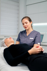 a cosmetologist gives instructions on how to care for a client's facial skin after a procedure in a...