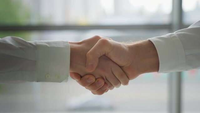 Close up Caucasian hands shaking formal friendly greeting welcome gesture hired invite hello handshaking shake arms palms cooperation partnership man and woman in office company deal trust agreement
