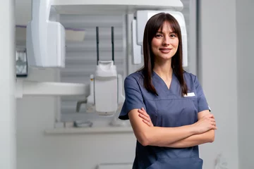 Poster portrait of a beautiful young female doctor dentist or radiologist in uniform standing with crossed arms in the beauty and health clinic © Guys Who Shoot