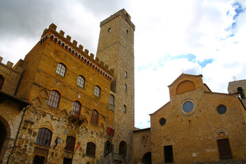 Torre Rognosa and the Duomo Collegiata di Santa Maria Assunta in the old town San Gimignano, Italy - obrazy, fototapety, plakaty