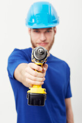Construction worker man, drill and studio portrait with hand for maintenance by white background. Person, employee or small business owner with power tools, helmet and job at repair services company