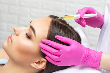 Cosmetologist does prp therapy of a beautiful woman in a beauty salon. Cosmetology concept.