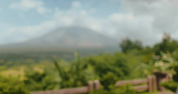 Woman enjoy view on Legazpi Mountains Volcano, Philippines. Asia wild nature tropical landscape. Tourist female relax, outdoor lifestyle travel on summer holiday vacation. Back view, slow motion