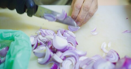 Close up chef hands using kitchen knife cutting chopping fresh shallots on white chopping board at the kitchen , preparing ingredient Thai food