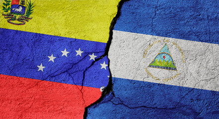 Venezuela and Nicaragua flags on a stone wall with a crack, illustration of the concept of a global crisis in political and economic relations