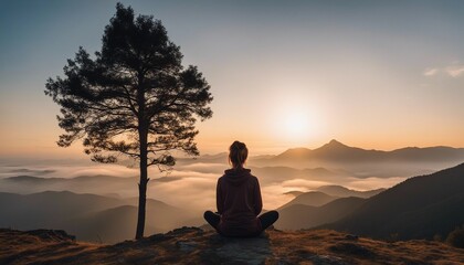 sporty Young woman meditating at dawn on a mountain with panoramic views, back view, sunrise, foggy weather