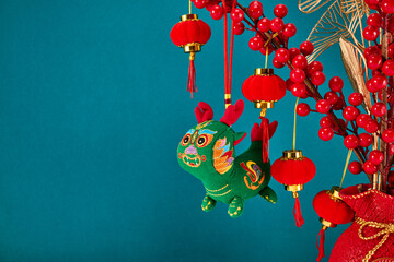 A New Year's toy in the shape of a green dragon hangs on a branch tree. Festive background. Chinese...